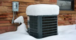 %Focuskw% | Grapids Home Services HVAC unit outside in the winter covered with snow in MI