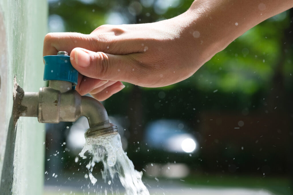 hand of woman she was using her hand to shut the flowing water from faucet
