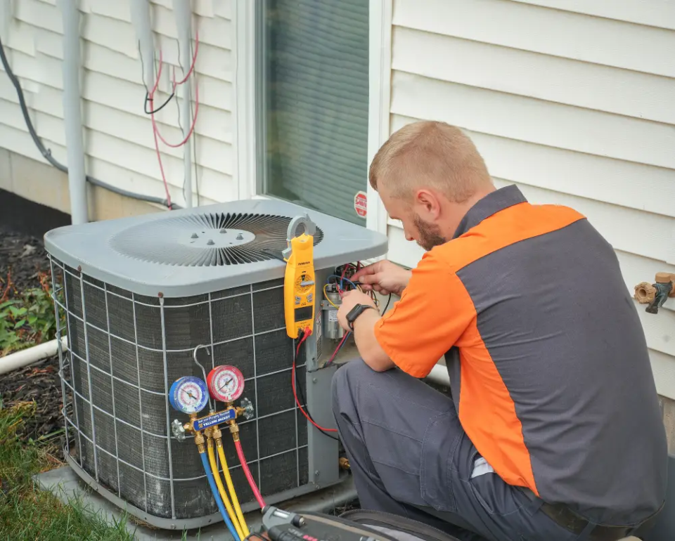 An HVAC technician inspects an AC unit to determine if repair or replacement is needed.