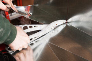 %Focuskw% | Grapids Home Services HVAC technician cutting sheet metal